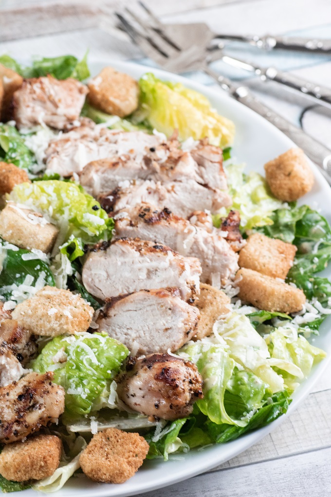 Grilled Chicken Caesar Salad on a white plate with a fork