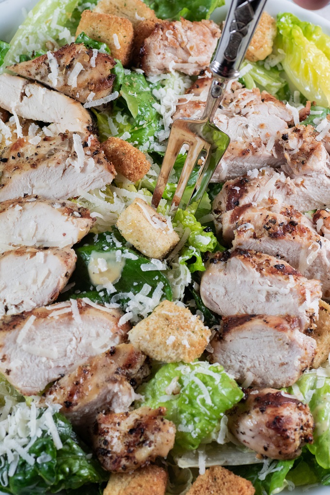 Grilled Chicken Caesar Salad with a fork picking up some salad