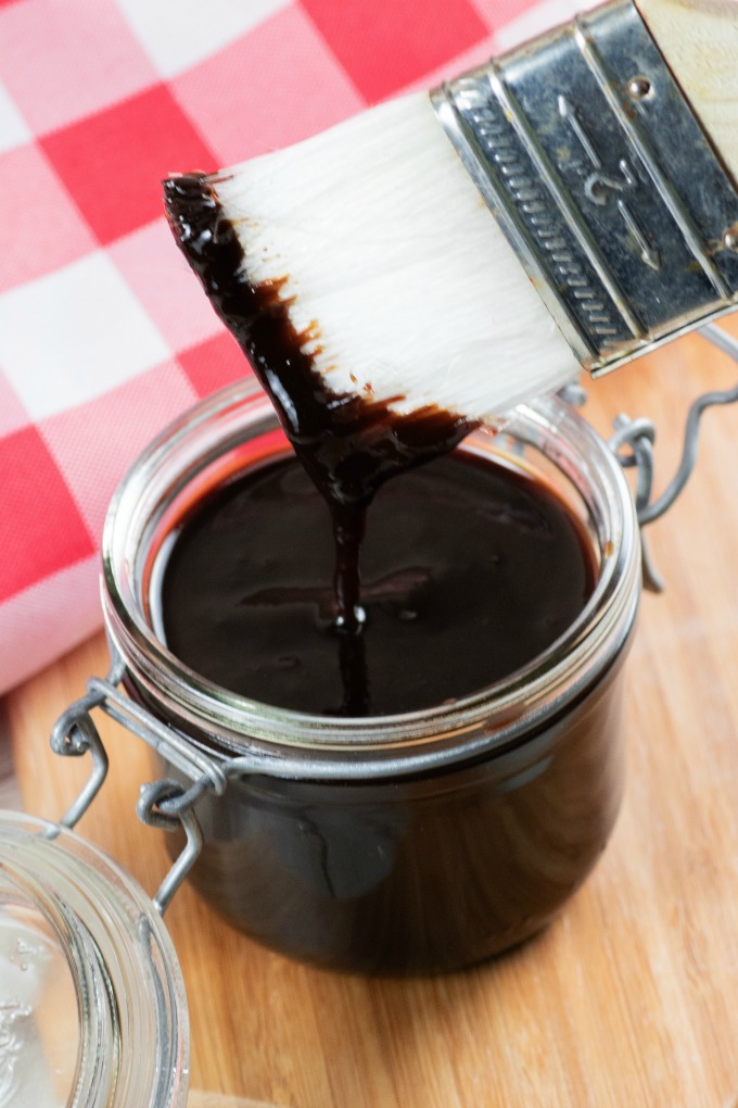 Brush dipped into a jar of homemade BBQ sauce