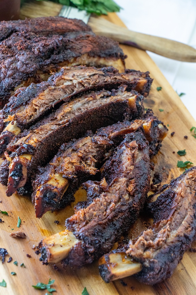 Sliced smoked beef ribs on a wooden board