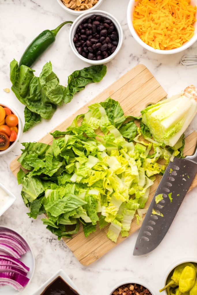 chopped head of romaine lettuce on a wooden cutting board