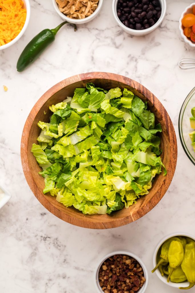 chopped romaine lettuce in a wooden salad bowl