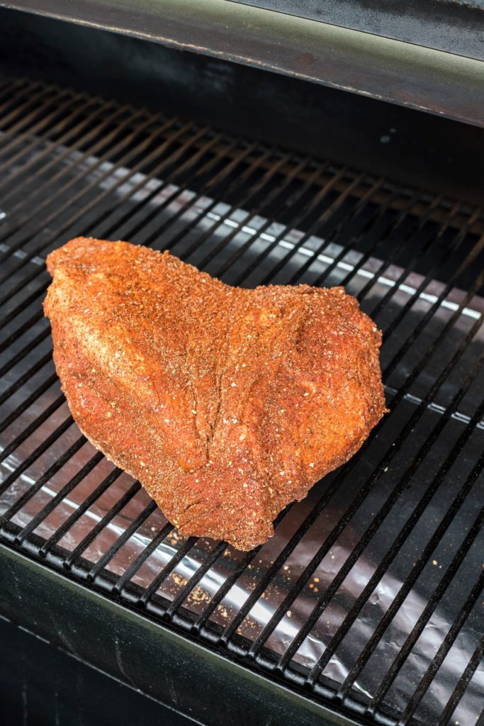 Briskt point covered with rub on a smoker grill