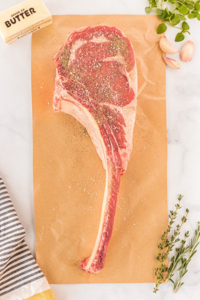 Ingredients for Grilled Tomahawk Steak on a wooden cutting board
