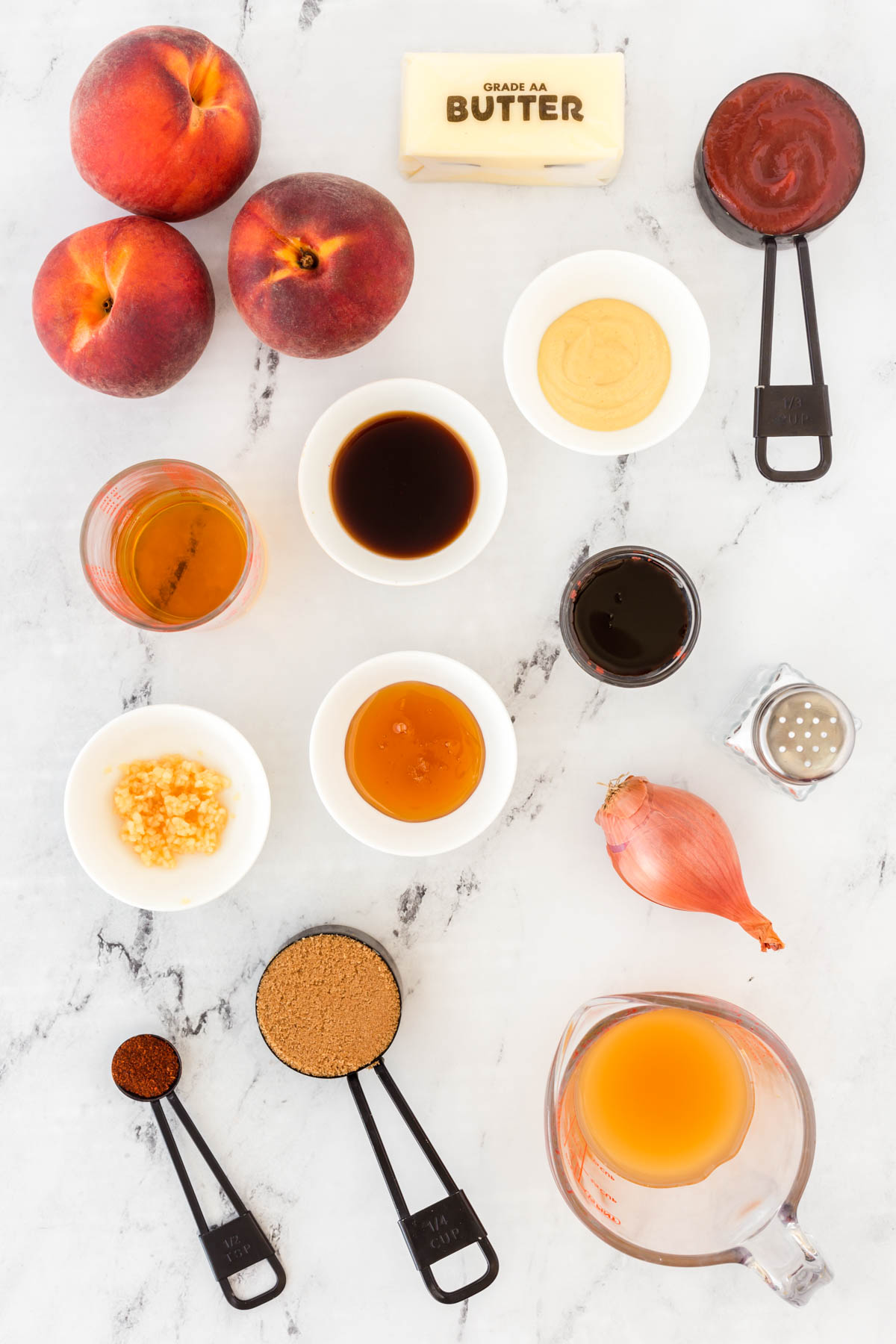 Peach Bourbon BBQ Sauce Ingredients laid out on a marble countertop.