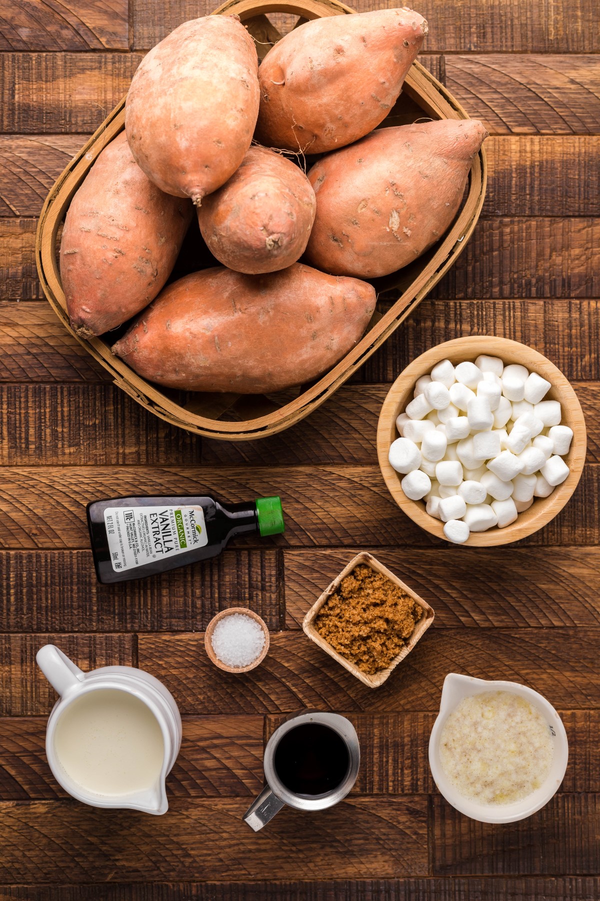 All the ingredients to make smoked sweet potatoes laid out on a wooden countertop.