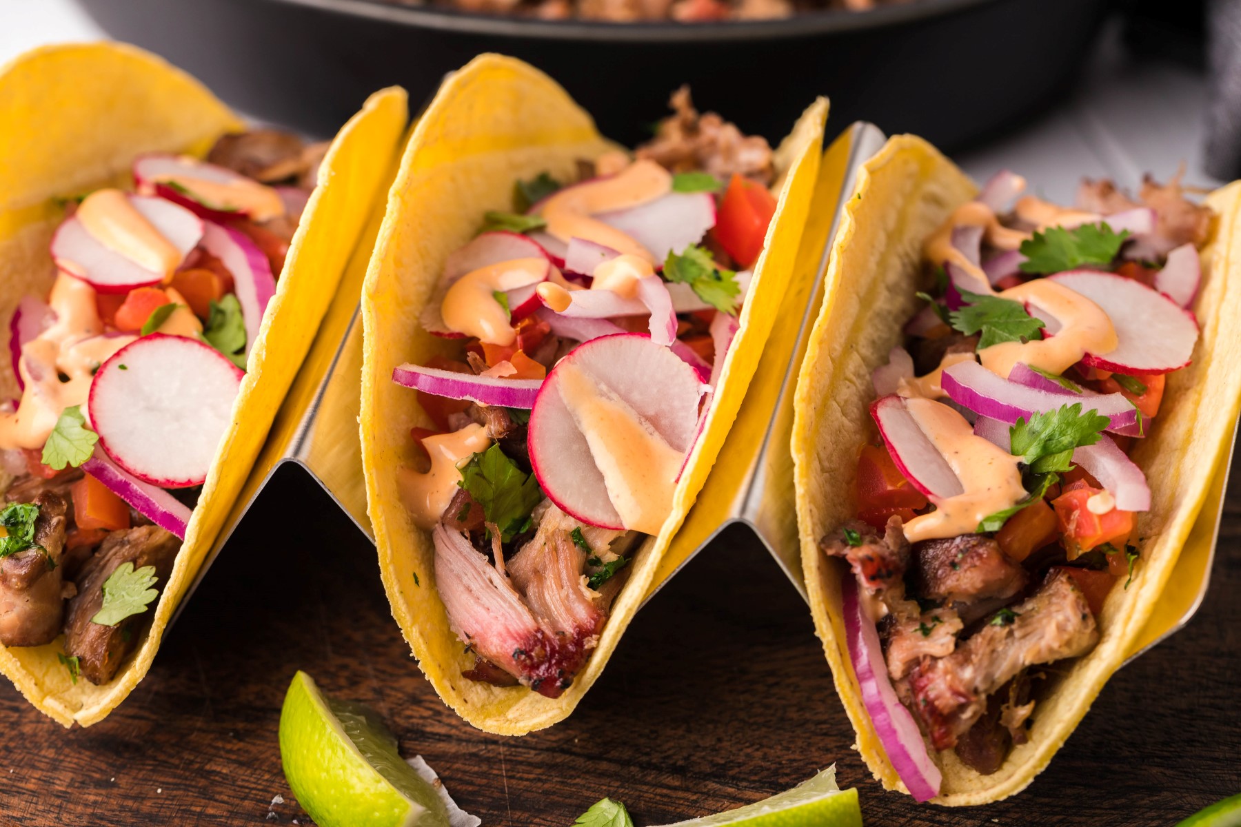 Smoked pork carnitas in soft corn tortillas filled with smoked pork, topped with red onions, sliced radishes, cilantro and spicy mayo.