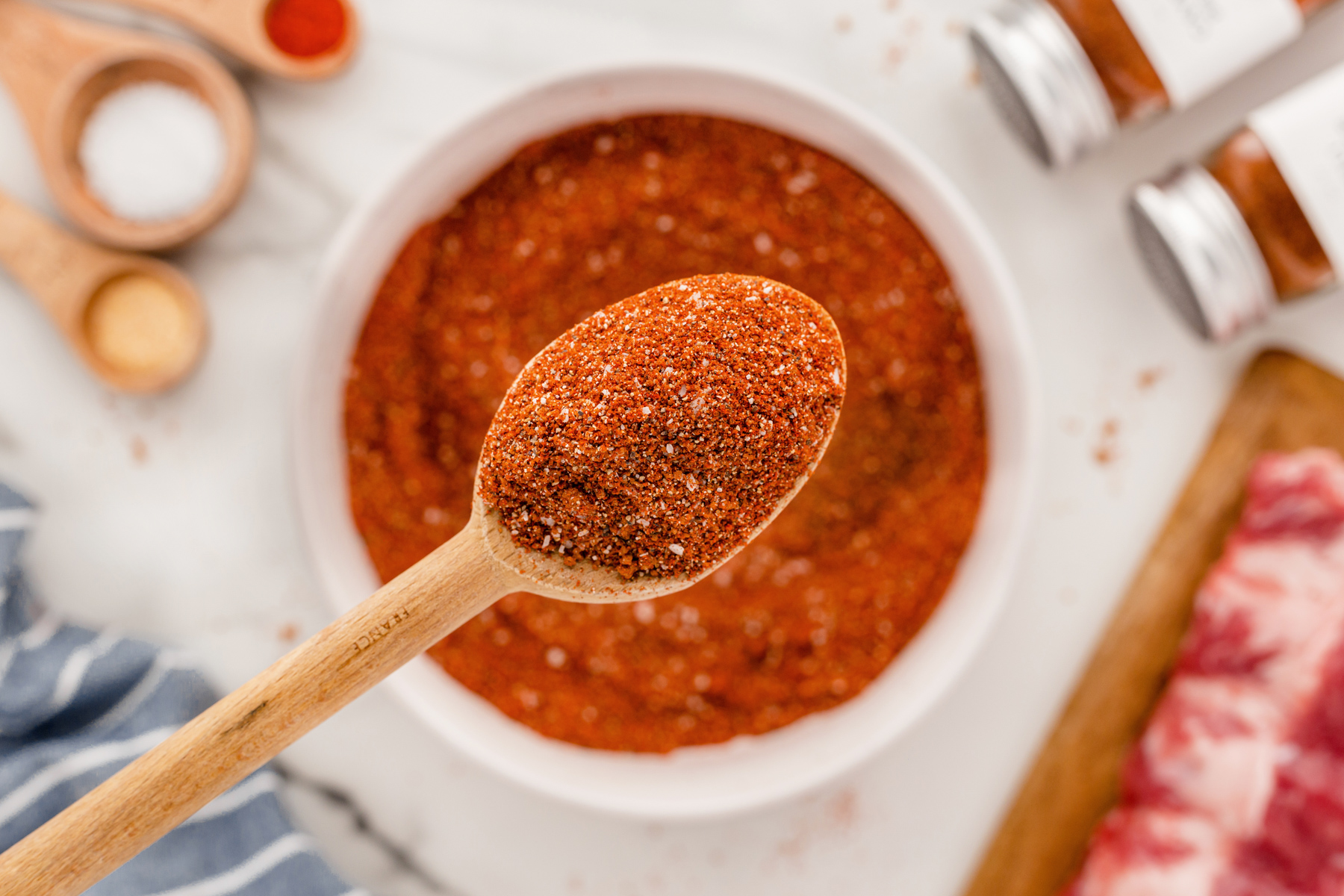 BBQ Rub on a wooden spoon over a bowl full of BBQ rub.