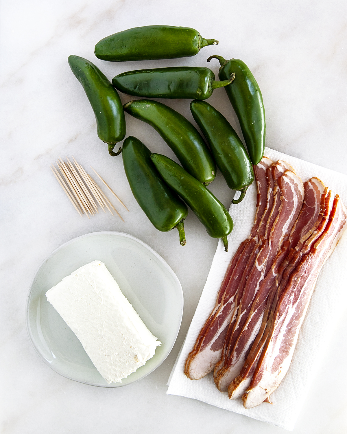 Ingredients to make grilled jalapeno poppers on a white countertop.
