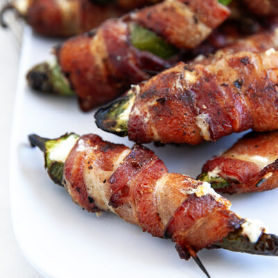 Bacon Wrapped Grilled Jalapeno Poppers on a white platter.