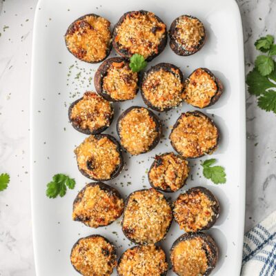 Goat cheese stuffed mushrooms on a white serving platter