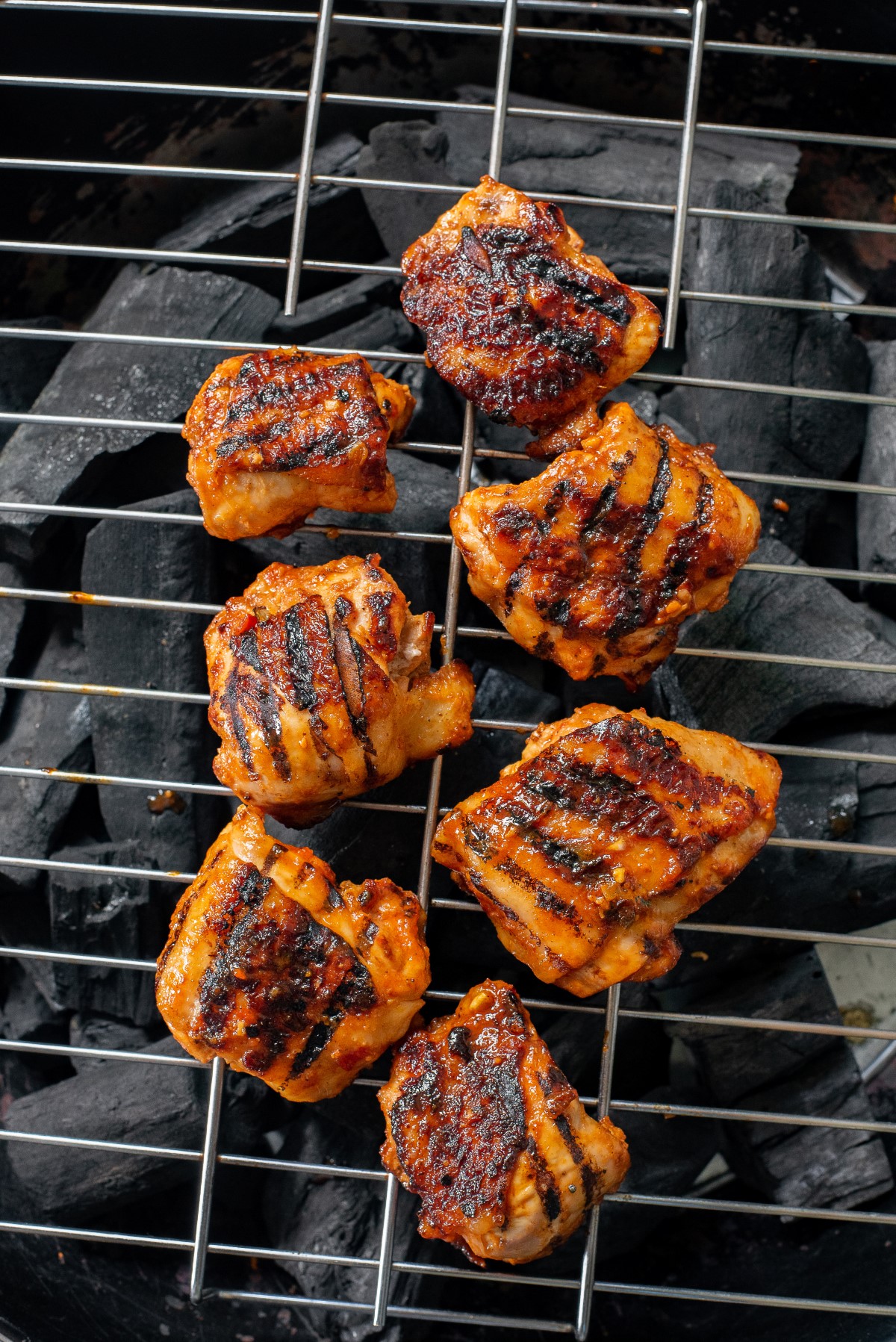 Harissa chicken thighs cooking on the grill.