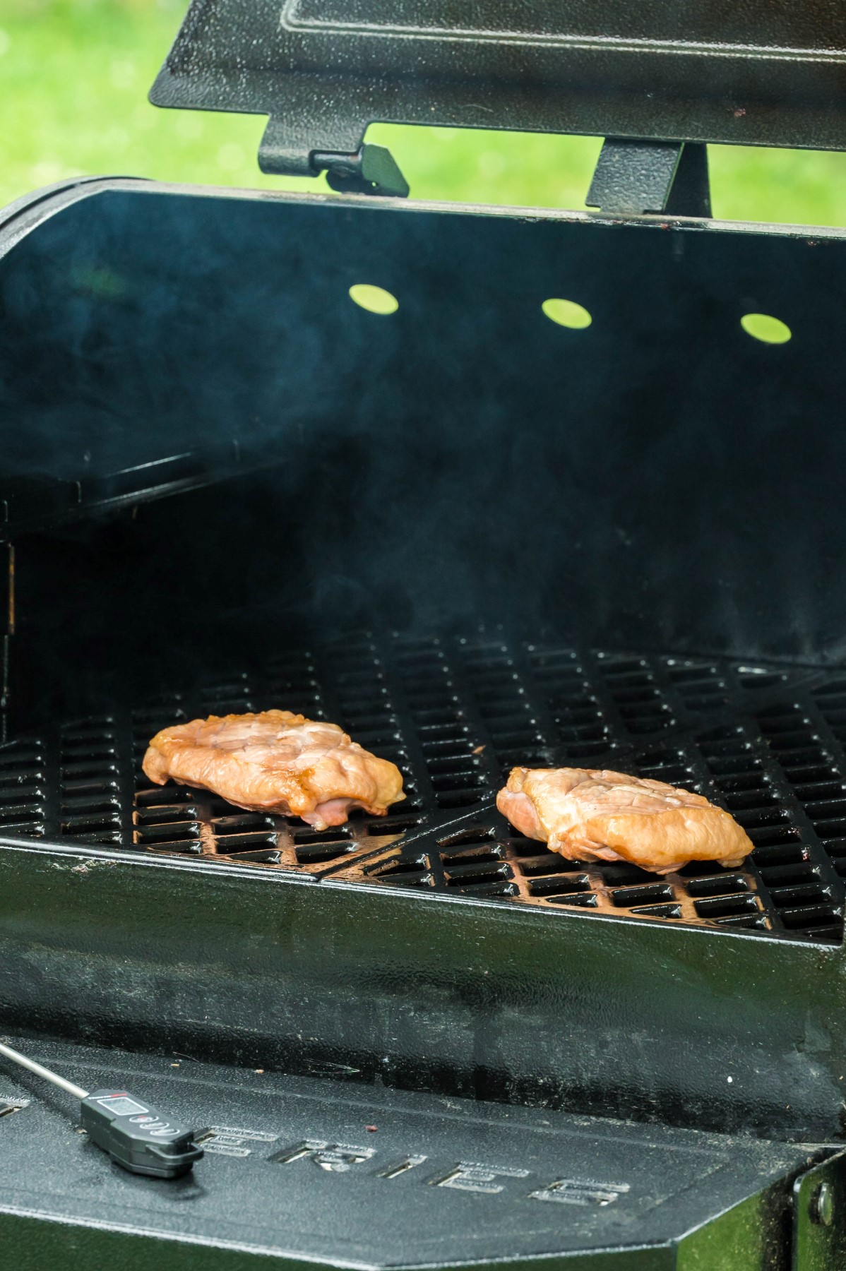 A pair of duck breasts smoking on the smoker grill.