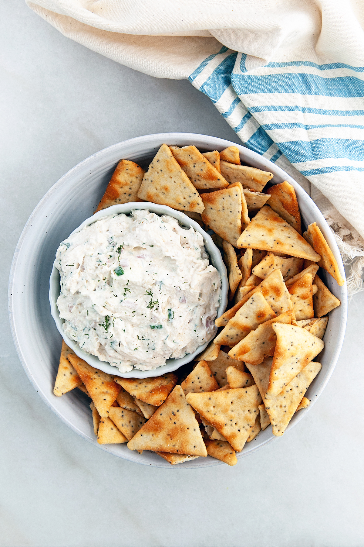 Smoked trout dip in a serving bowl with crackers on the side.